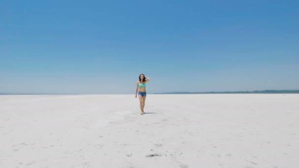 Una mujer caminando sobre un lago de sal muy blanco en Chipre — Vídeos de Stock