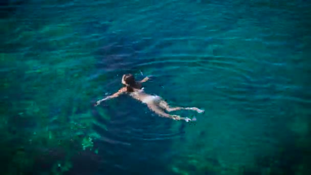 Mujer joven nadando en hermoso mar azul — Vídeos de Stock