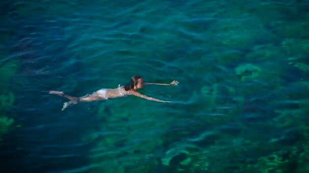 Jonge vrouw, zwemmen in mooie azuurblauwe zee — Stockvideo
