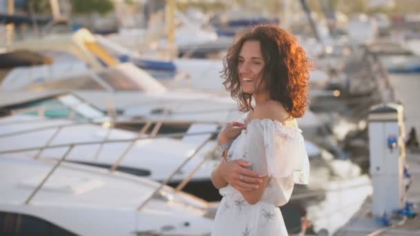 Hermosa joven sonriendo en un muelle en un día de verano — Vídeos de Stock