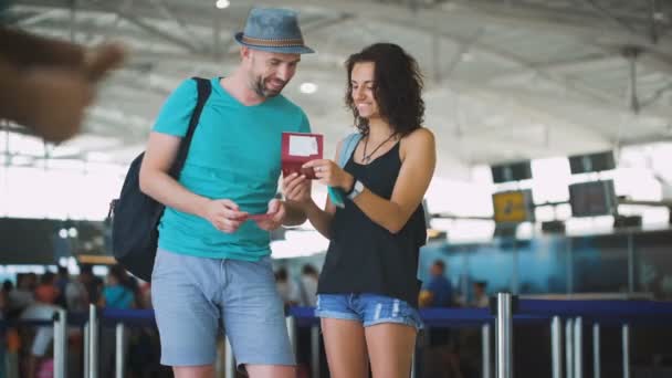 Hermosa pareja feliz hablando de su viaje a una isla. Mirando el pasaporte que discuten sus vacaciones — Vídeos de Stock