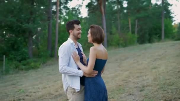 Романтична пара молодих людей охоплює розселення в літньому лісі . — стокове відео