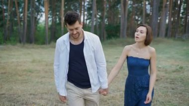 Young couple walking in the woods or the park, not far from his home.