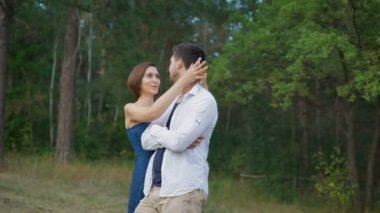 Romantik çift genç, yaz ormanında bir açıklık kucaklayan.