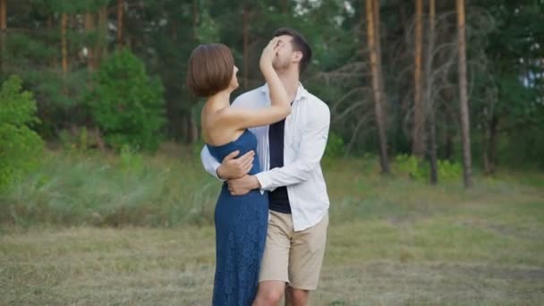 Couple romantique de jeunes gens embrassent une clairière dans la forêt d'été . — Video