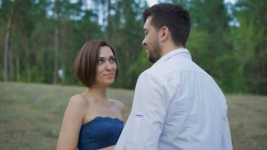 Romantik çift genç, yaz ormanında bir açıklık kucaklayan.