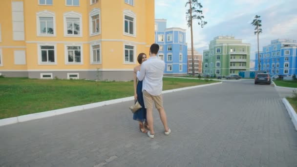 Uomo e donna passeggiando lungo la zona residenziale alla moda . — Video Stock