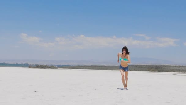 Eine Frau läuft an einem sehr weißen Salzsee in Zypern — Stockvideo