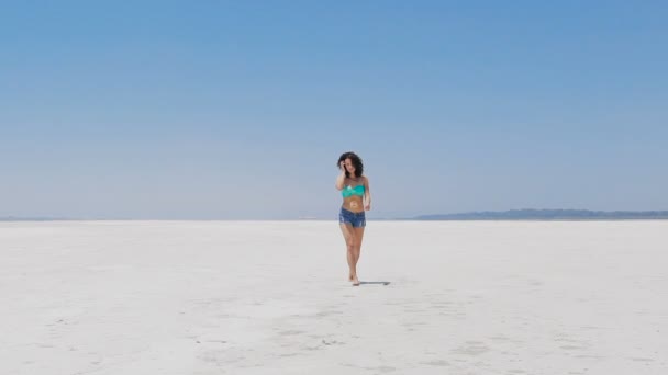 Una mujer caminando en un lago de sal muy blanco en Chipre — Vídeo de stock