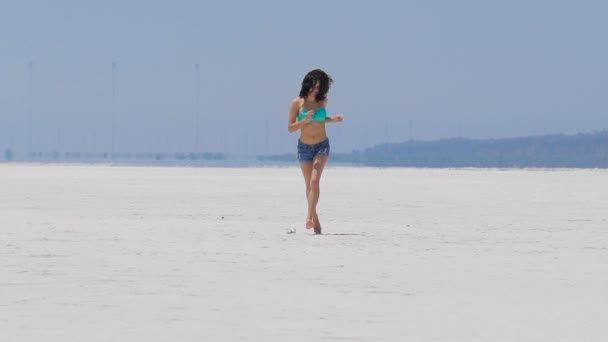 Uma mulher correndo em um lago de sal muito branco em Chipre — Vídeo de Stock