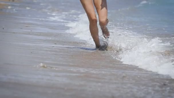 Las piernas de una hermosa chica corriendo en una playa — Vídeos de Stock