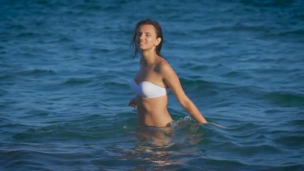 Hermosa modelo de bikini sexy joven girando en el mar — Vídeo de stock