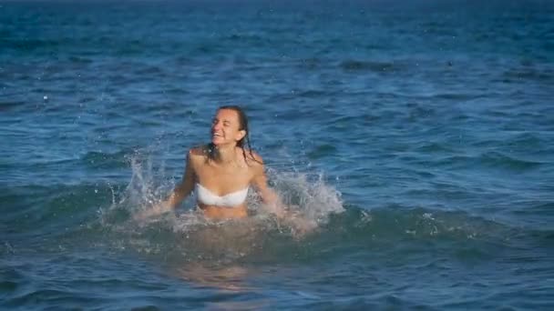 Una joven hermosa mujer saltando en el mar — Vídeo de stock