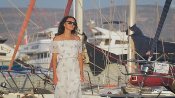 A beautiful sexy woman walking at a port and smiling thinking about the happy moments — Stock Video