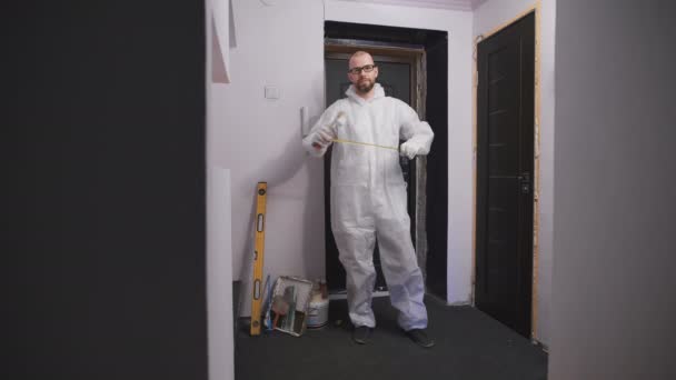 Професійна робота моляр в білому захисному костюмі, готовий почати ремонт . — стокове відео