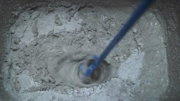 Beton mengen. Werk bouw kneed het mengsel met behulp van een elektrische mixer. — Stockvideo