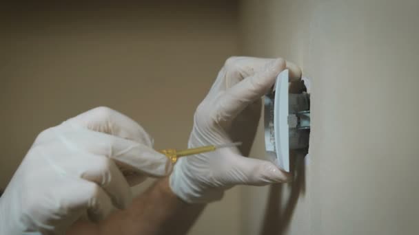 Veranderen van kamer muur lichtschakelaar installatie met een schroevendraaier, handen close-up elektricien. — Stockvideo