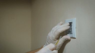 Oda duvar ışık anahtarı yükleme bir tornavida ile değiştirme, yakın çekim elektrikçi eller.