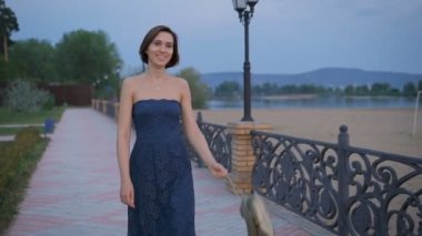 Aktif genç kadın briskly, onu çanta altın kahverengi elinde yürüyor.