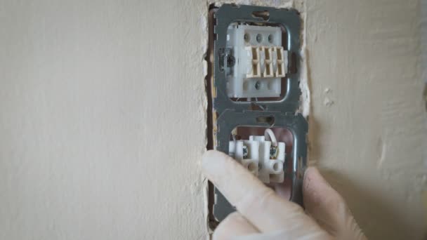 Veranderen van kamer muur lichtschakelaar installatie met een schroevendraaier, handen close-up elektricien. — Stockvideo