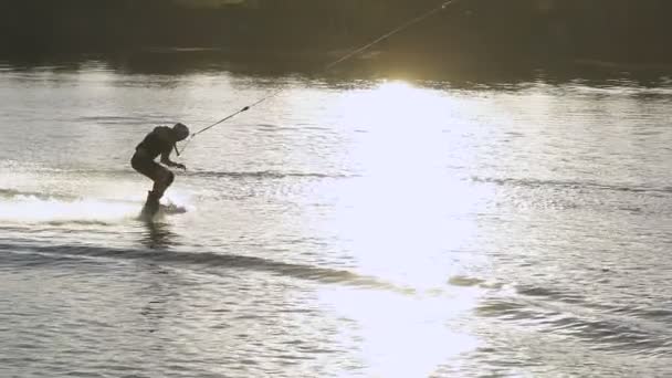 Wakeboarder haciendo trucos al atardecer — Vídeos de Stock