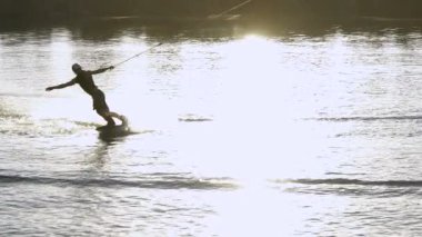Wakeboarder günbatımı üzerinde hileler yapmak