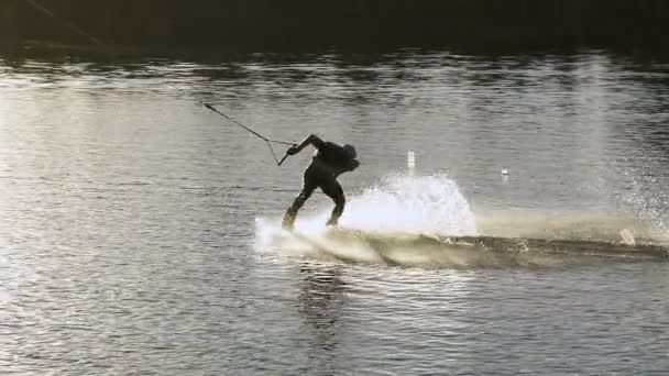 Wakeboarder haciendo trucos al atardecer — Vídeos de Stock