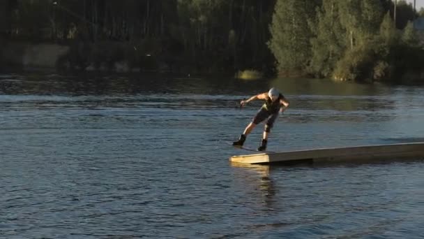 Wakeboarder haciendo trucos al atardecer — Vídeo de stock