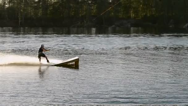 Wakeboarder haciendo trucos al atardecer — Vídeos de Stock