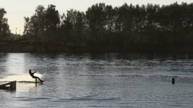 Wakeboarder günbatımı üzerinde hileler yapmak