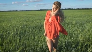 Mutlu bir görünüm ayakta ve yeşil bir alanda kendini zevk ile güzel genç sarışın kadın