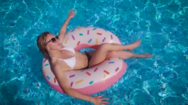 Wanita ramping yang menarik berenang pada lingkaran inflatable. Sebuah kolam renang dengan air bersih. — Stok Video