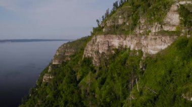 Kayalık dağdan ve kıyıdan bak. Rusya 'nın merkez şeridinde yaz doğası. Taş uçurumlar ve bitki örtüsü.