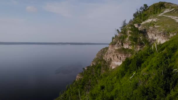 Flight along a picturesque cliff above the river. A huge reservoir and a steep stone cliff. — Stock Video