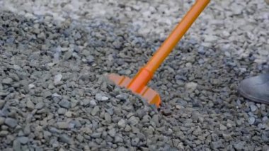 Adamın biri moloz kazmak için plastik kürek kullanıyor. İnşaat alanında sıkı çalışma