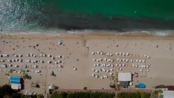 Vista aérea. Vista superior da linha de praia do mar Mediterrâneo. No quadro, a área de resort da praia com guarda-sóis e espreguiçadeiras. — Vídeo de Stock