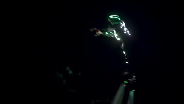 Flyboard, un nouveau sport et spectacle. Un surfeur dans un casting rétro-éclairé montre des tours dans la nuit. — Video