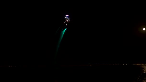Pesawat terbang, diterangi di malam hari. Atlet melakukan aksi berbahaya selama pertunjukan mereka. — Stok Video