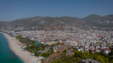 Hava görüntüsü. Türk tatil beldesi Alanya 'da güzel bir yaz günü. Çerçevede, kumsalı olan deniz ve etrafındaki dağlar..