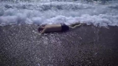 Denizde boğulan yetişkin bir adamın cesedi. Suda alkolizm çok tehlikelidir. Boğulan adam kurtarıcılar tarafından bulunacak..