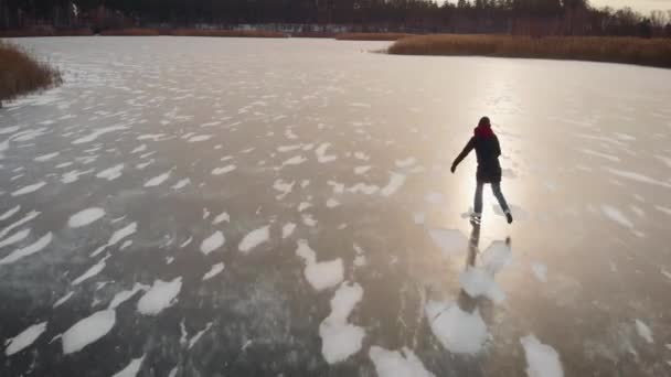 Letecký pohled. Mladá žena bruslí na zamrzlém jezeře. — Stock video