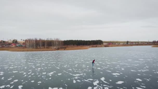 공중에서 본 모습. 한 젊은 여자가 얼어붙은 호수에서 스케이트를 타고 있다. — 비디오