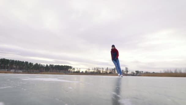 Dexterous mladá žena bruslí na ledě v přírodě. Bílé brusle jsou skvělé pro zimní zábavu — Stock video