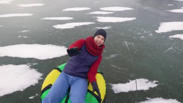 Atraktivní mladá žena je tubing na ledě. — Stock video