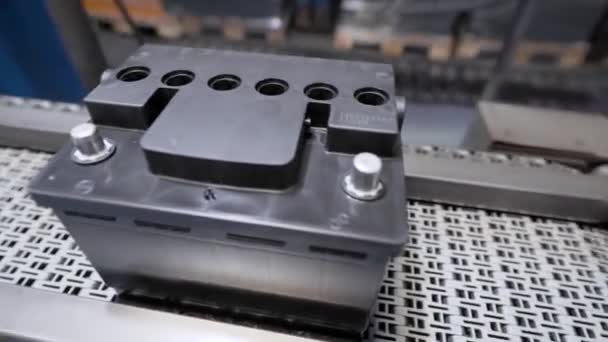 Linea automatica per il montaggio di batterie per auto. Le batterie nere si muovono e si raccolgono sul nastro trasportatore. — Video Stock