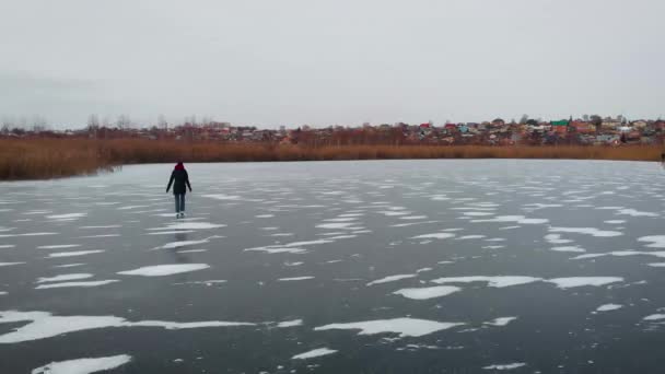 Letecký pohled. Mladá žena bruslí na zamrzlém jezeře. — Stock video