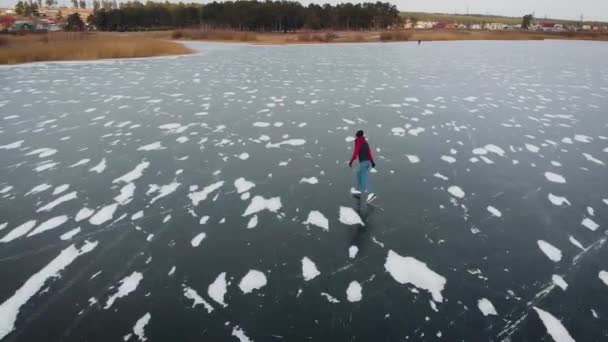 Letecký pohled. krásná zmrzlá řeka nebo jezero. Muž bruslí na ledě. — Stock video