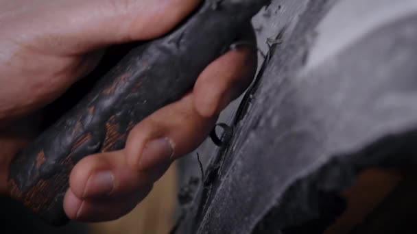 Um close-up de um homem mão com uma ferramenta. Um profissional remove a forma do barro com a ajuda de um ciclo. A produção — Vídeo de Stock