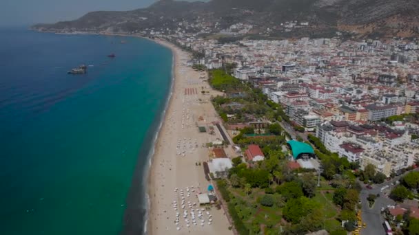 Hava görüntüsü. Türk tatil beldesi Alanya 'da güzel bir yaz günü. Çerçevede, kumsalı olan deniz ve etrafındaki dağlar.. — Stok video