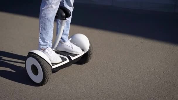 A man rides hoverboard on a city road. Modern elestro transport is convenient and environmentally friendly. — Stock Video